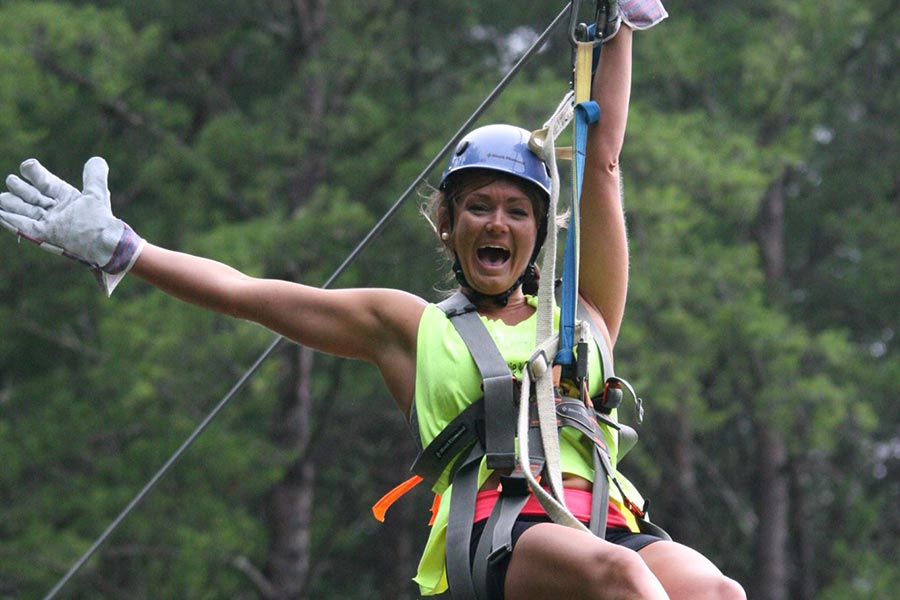 Woman zip lining with Raft One Outfitters